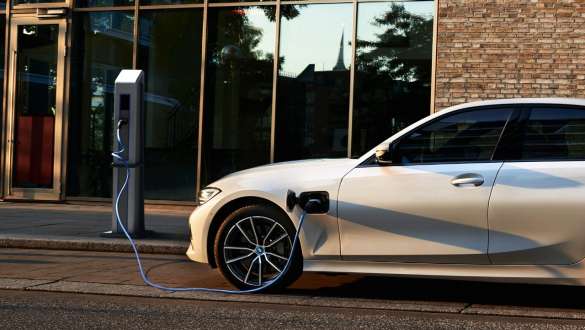 Plug-in hybrid BMW 3 Series Sedan 2021 G20 side view Plug-in hybrid BMW 3 Series Sedan 2021 G20 side view on charging station
