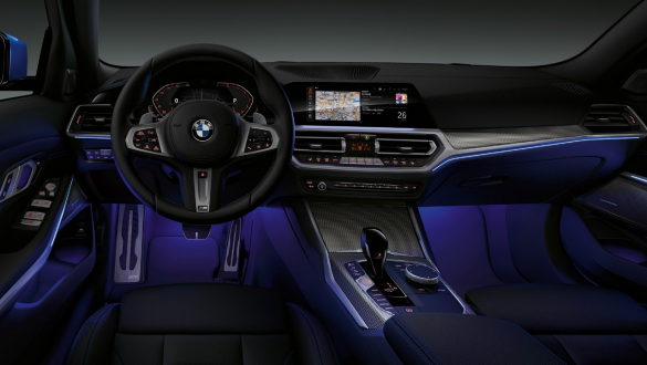 BMW 3 Series Sedan, Ambient light Front view of the driver's cockpit of the BMW 3 Series Sedan with by Ambient light blue illuminated legroom.