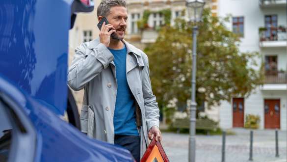 Man standing behind BMW trunk BMW 5 Series Touring G31 Man standing at BMW trunk with Smartphone and warning triangle BMW 5 Series Touring G31 Facelift 2020
