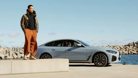 BMW Service Inclusive man in front of BMW i4 (G26) on the coast BMW Service Inclusive man in front of BMW i4 (G26) on the coast