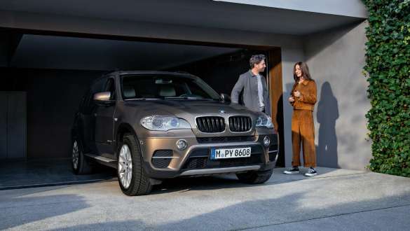 BMW Value Service BMW Value Service Man and woman standing on driveway next to BMW vehicle