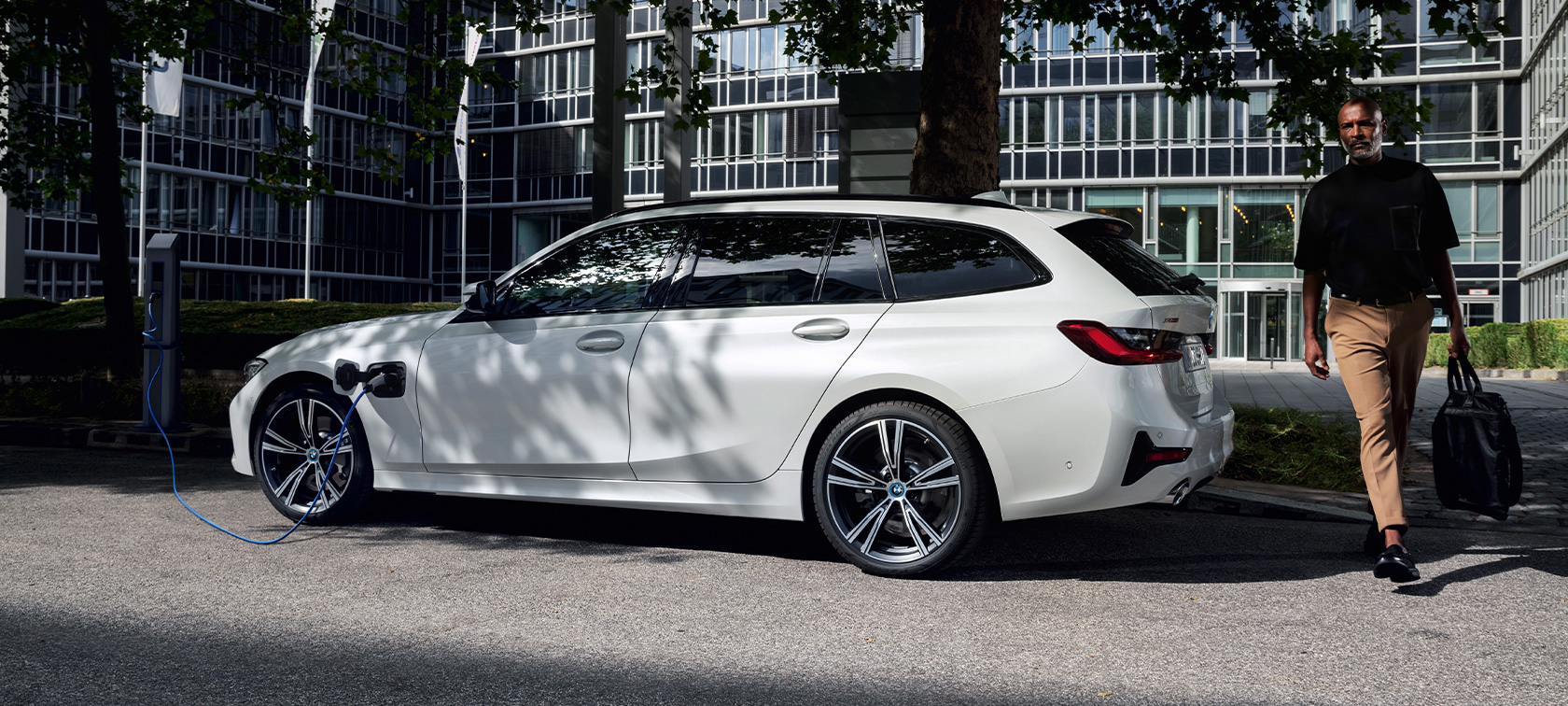 Plug-in hybrid BMW 3 Series Touring 2021 G21 three-quarter side view charging Plug-in hybrid BMW 3 Series Touring 2021 G21 three-quarter side view charging with model