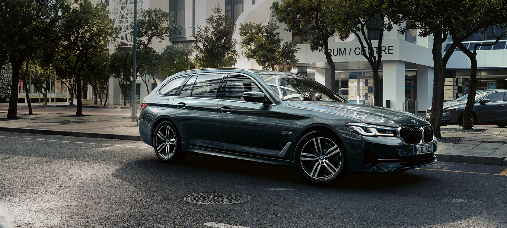 BMW 5 Series Touring G31 Facelift 2020 Sophisto Grey 7/8 front view driving near the outskirts