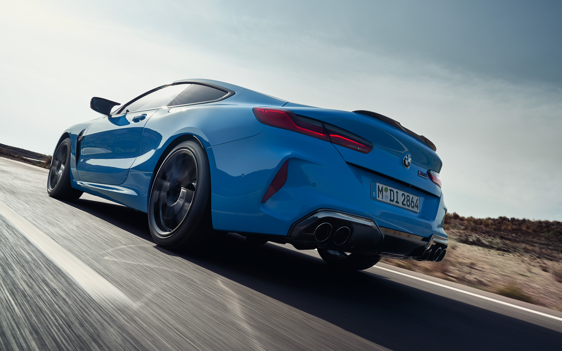 BMW M8 Competition Coupé F92 LCI 2022 three-quarter rear view driving BMW M8 Competition Coupé F92 LCI Facelift 2022 Daytona Beach blue uni three-quarter rear view driving on a highway