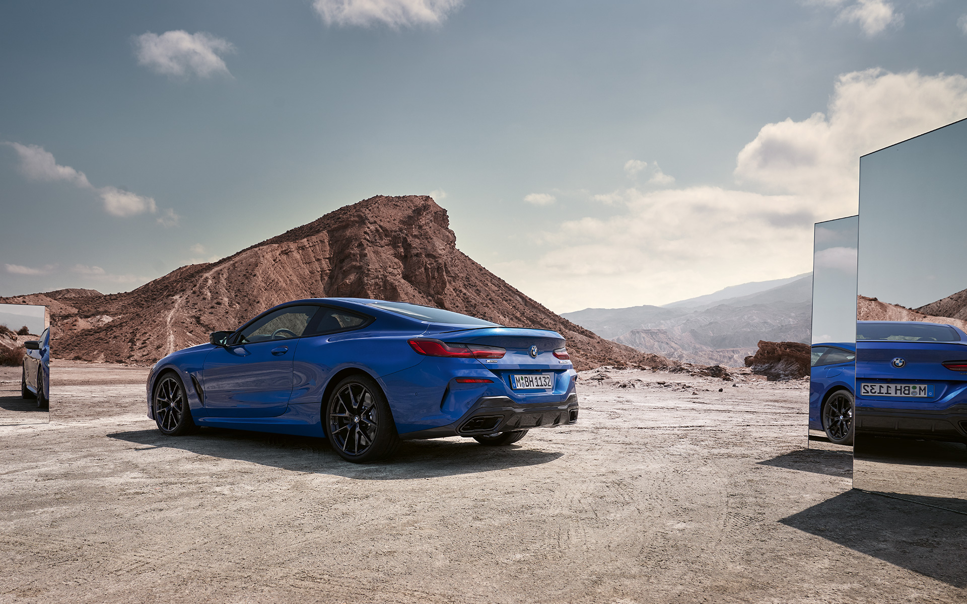 BMW M850i xDrive Coupé G15 LCI Facelift 2022 rear view standing BMW M850i xDrive Coupé G15 LCI Facelift 2022 M Portimao Blue metallic rear view standing with mirrors