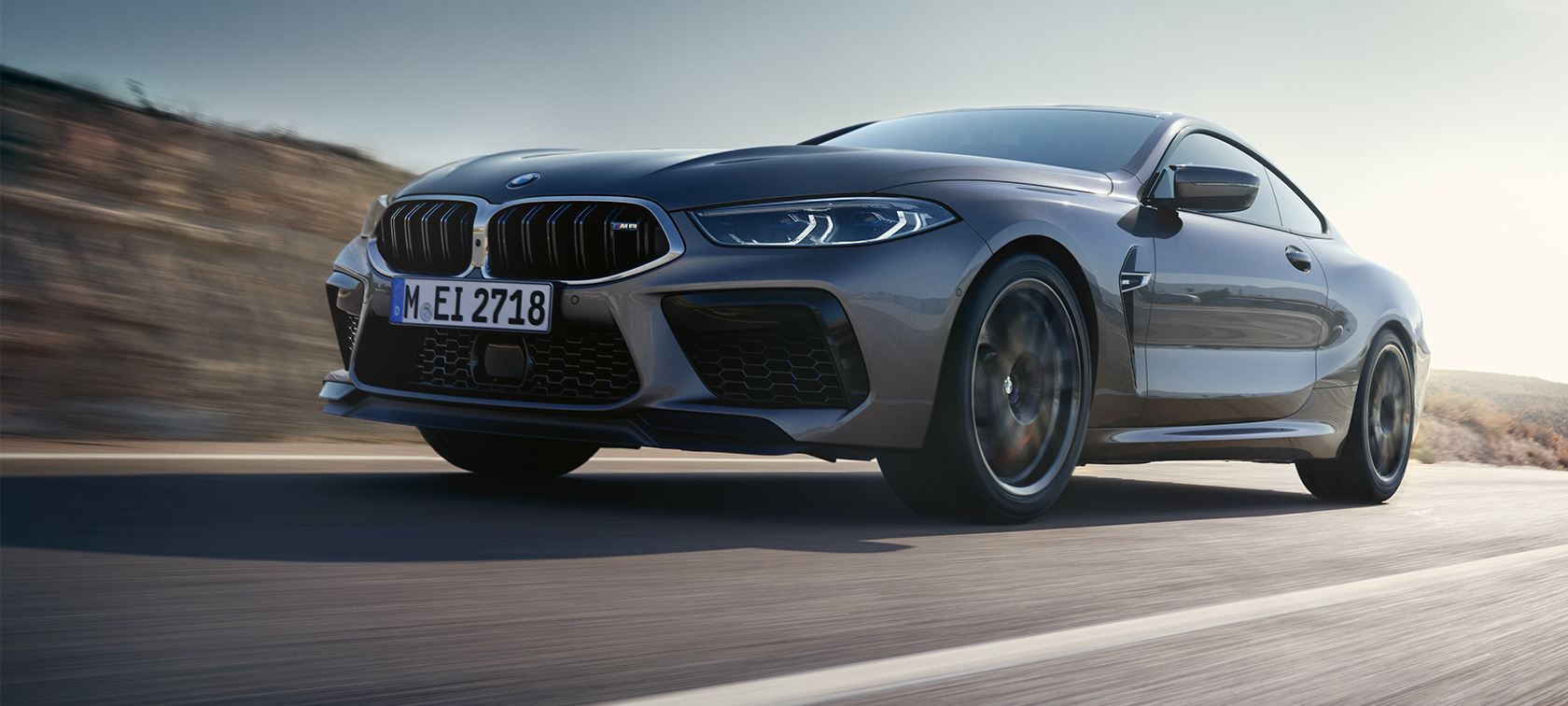 BMW M8 Coupé F92 LCI Facelift 2022 three-quarter side view driving BMW M8 Coupé F92 LCI Facelift 2022 Skyscraper grey metallic three-quarter side view low angle shot