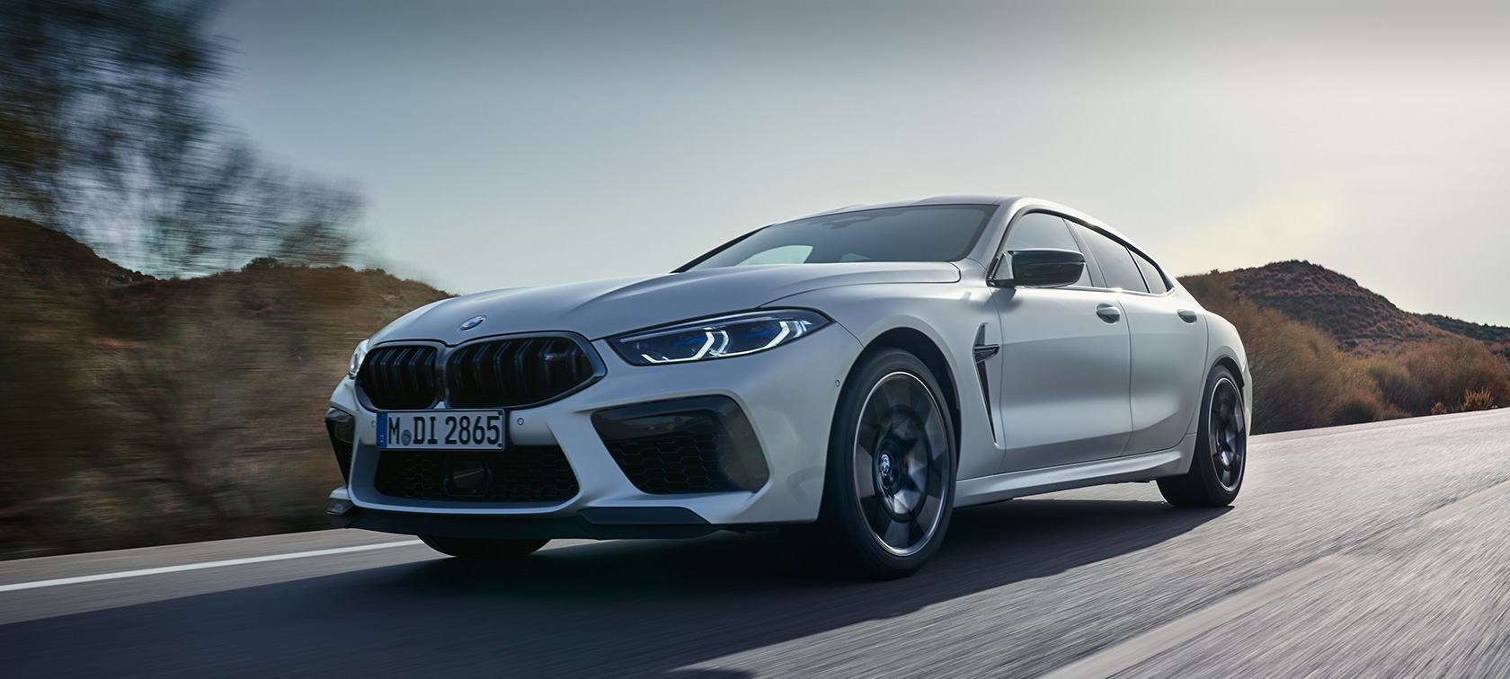 BMW M8 Competition Gran Coupé F93 LCI 2022 three-quarter front view driving BMW M8 Competition Gran Coupé F93 LCI Facelift 2022 BMW Individual Frozen Brilliant White metallic three-quarter front view driving