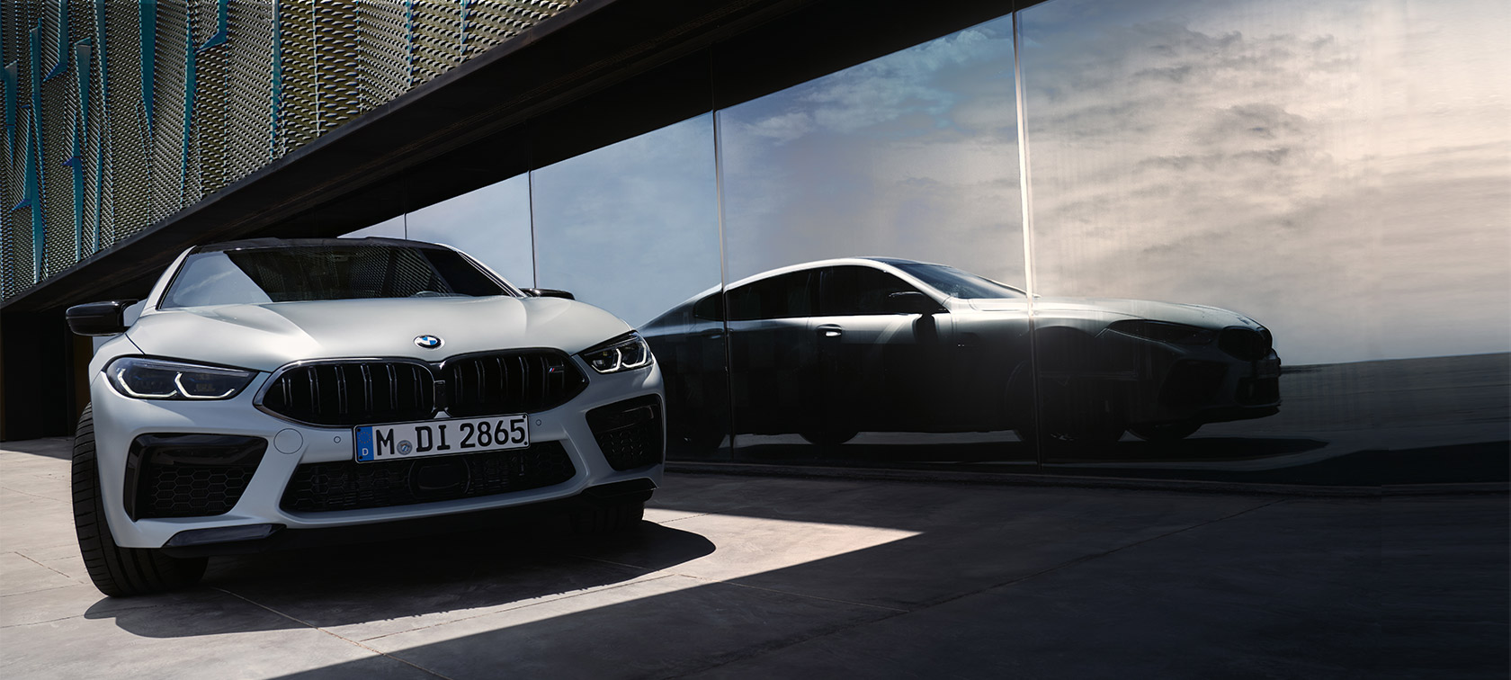 Front view the BMW M8 Competition Gran Coupé F93 LCI Facelift 2022 The BMW M8 Competition Gran Coupé F93 LCI Facelift 2022 BMW Individual BMW Individual Frozen Brilliant White metallic front view with reflection of silhouette on the window front