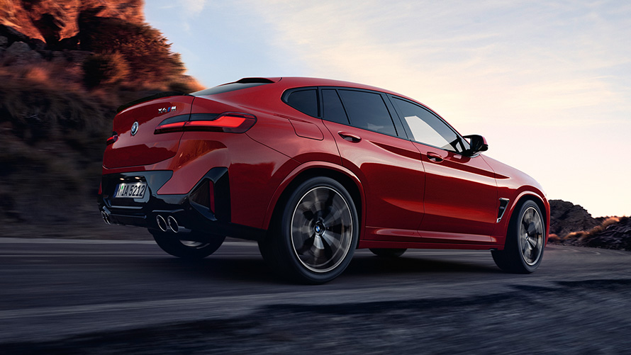 BMW X4 M F98 LCI Facelift 2021 Toronto Red metallic three-quarter rear view driving on the road