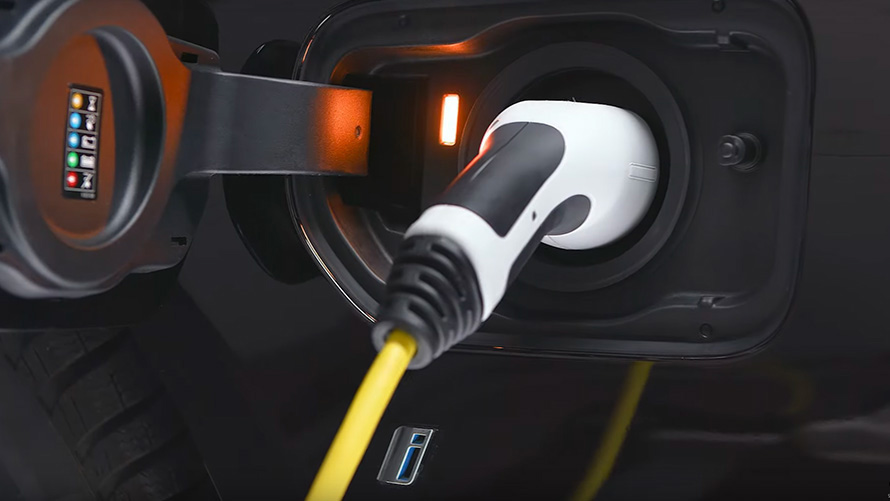 BMW plug-in hybrid connected with charging cable BMW plug-in hybrid connected with charging cable close-up