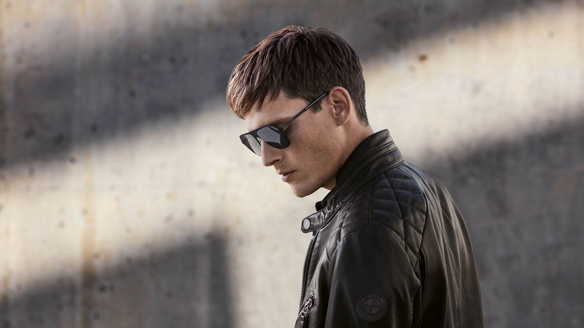 BMW Men's Leather Jacket. Side-profile shot of a man wearing the BMW Men's Leather Jacket from the BMW Collection.