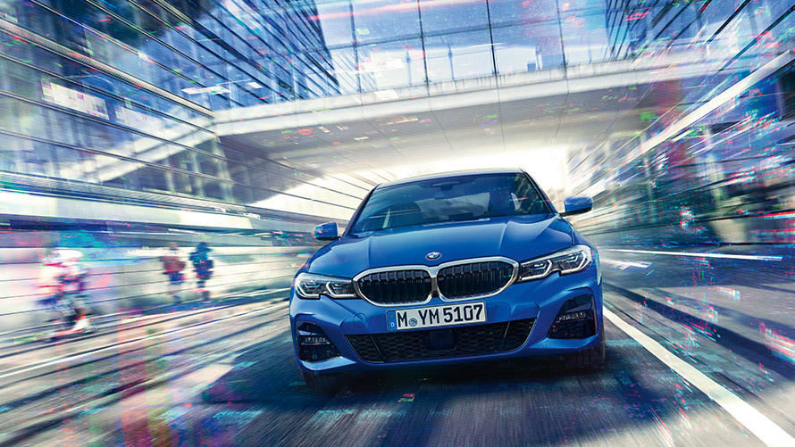Driving shot of a blue BMW Driving shot of blue BMW with glass overpass in the background