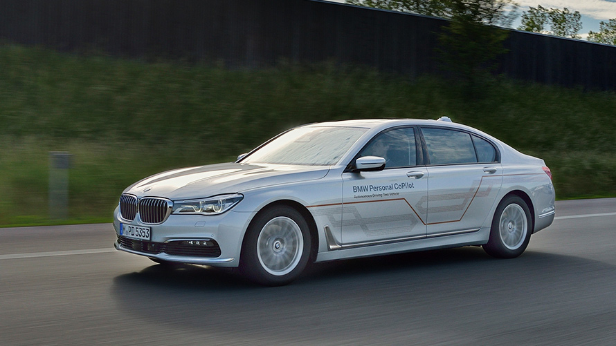 Grey BMW 7 Series Sedan A grey BMW 7 Series Sedan drives in a bridge with a skyline in the background