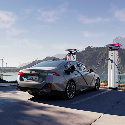 BMW i5 eDrive40 G60 at charging station in front of a lake