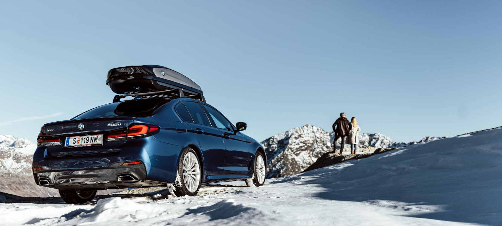 Original BMW Accessories and BMW Service for autumn and winter Woman and man laughing on toboggan tyres in snow