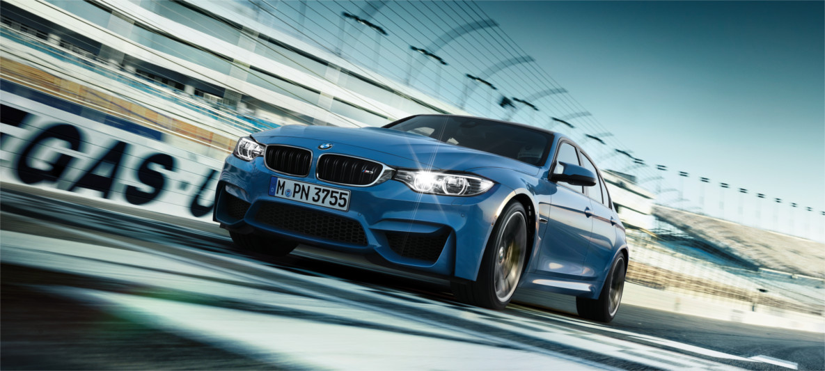 BMW M2 – Compact Sports Car with Bold Design and Racing DNA Front view of a blue BMW M2 racing on a track with motion blur, highlighting aggressive styling and track-capable performance"